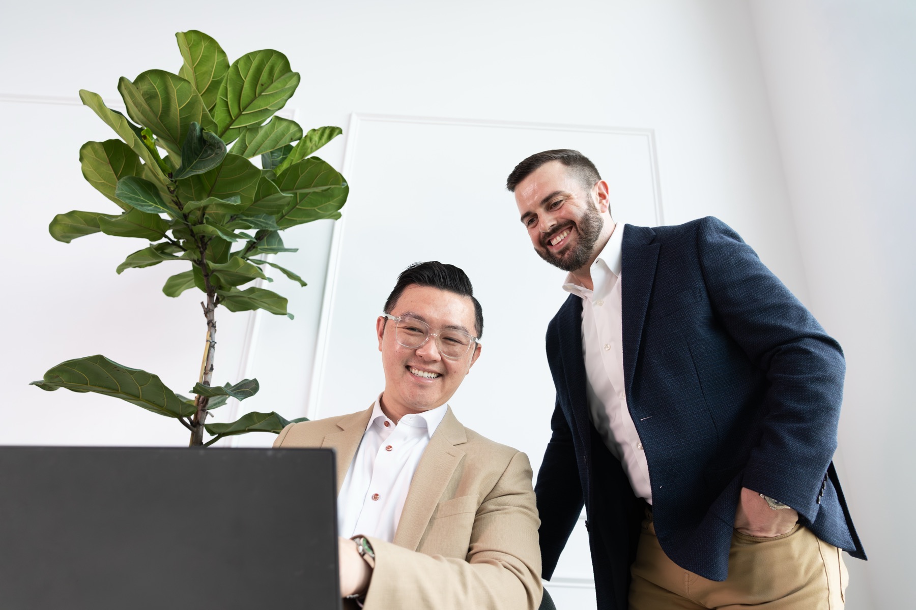 Two advisors reviewing deal data together in a sunlit office.